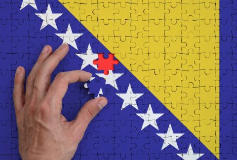 bosnia-and-herzegovina-flag-is-depicted-on-a-puzzle-which-the-mans-hand-completes-to-fold_t20_pR4XWO